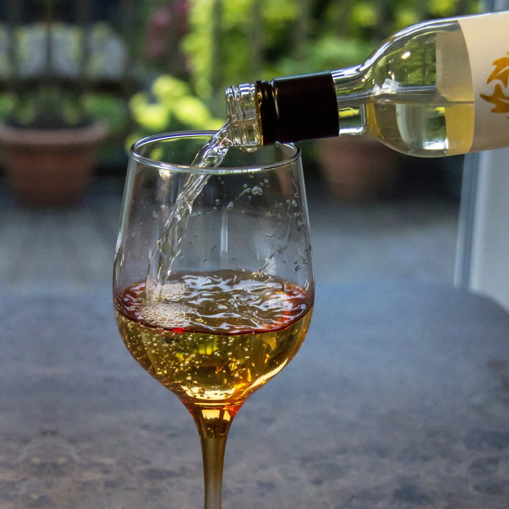 Photo showing a bottle pouring wine into a glass to support text about moderation and wellness. 